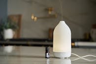 Minimalist diffuser with essential oil bottle on kitchen countertop, exuding a calming atmosphere.